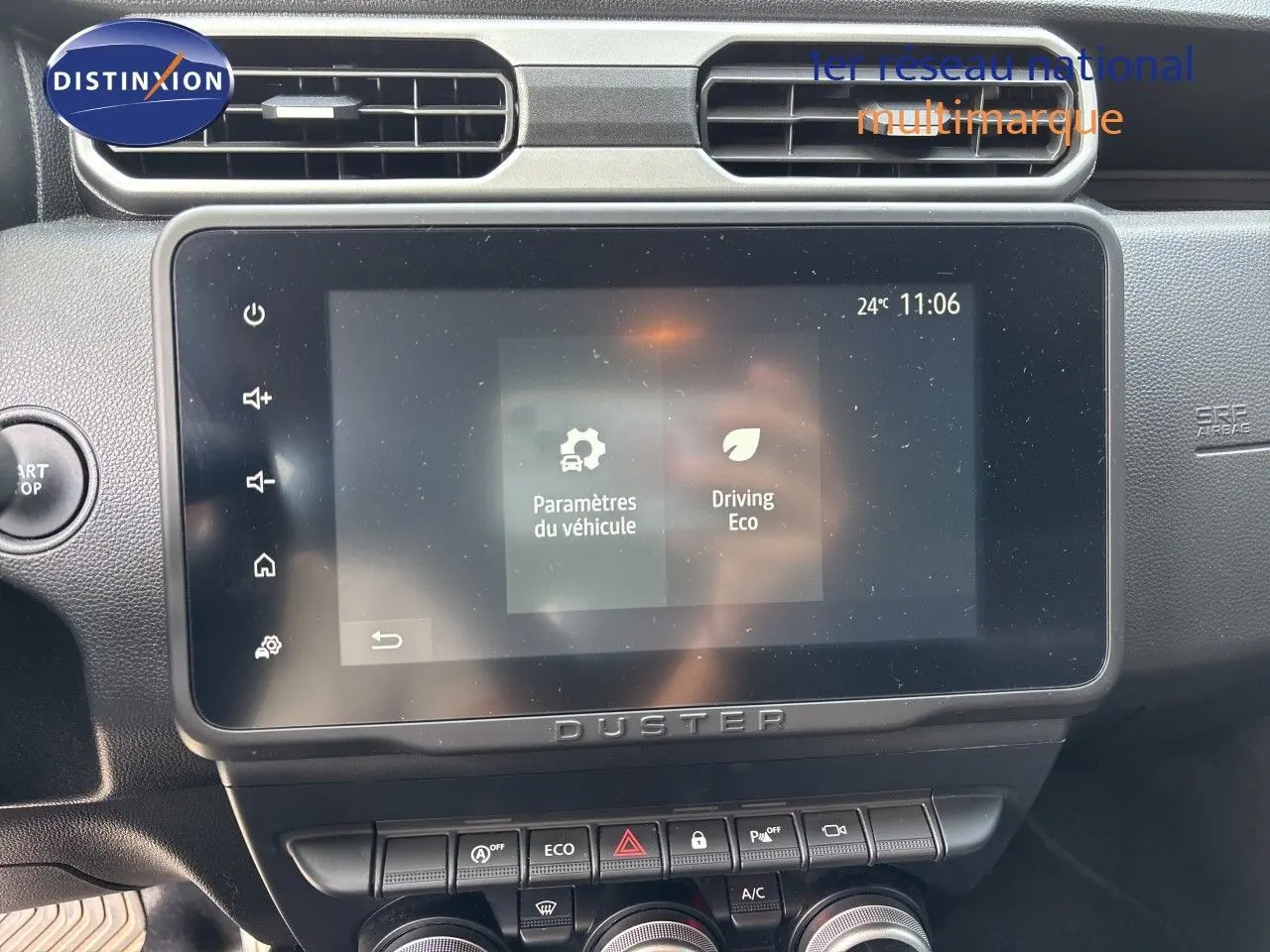 Écran tactile central du Dacia Duster 2024 noir, vue frontale du tableau de bord avec commandes climatisation et démarrage.