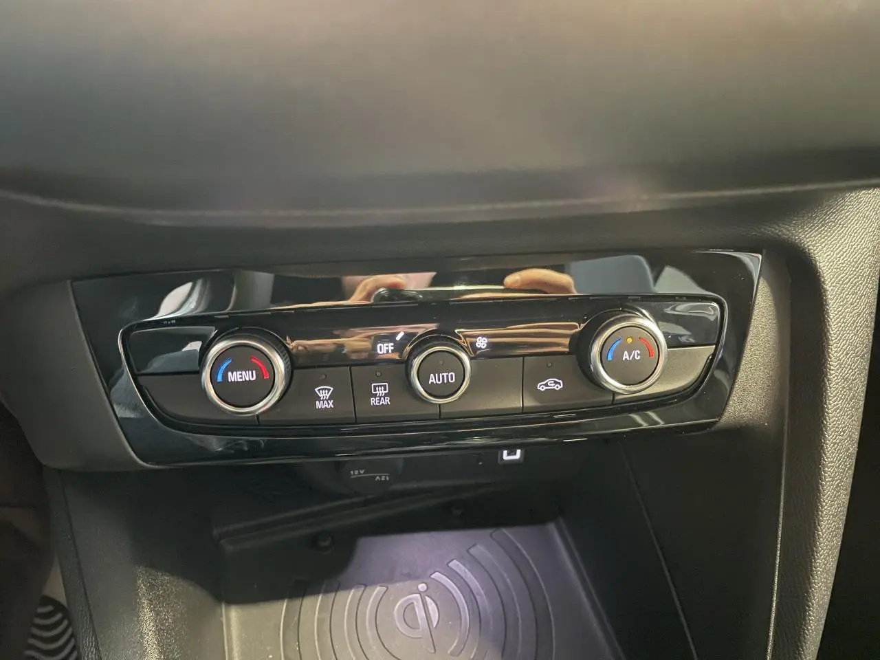 Détail de la console centrale noire de l’Opel Corsa blanche 2026 avec commandes de climatisation et chargeur induction.