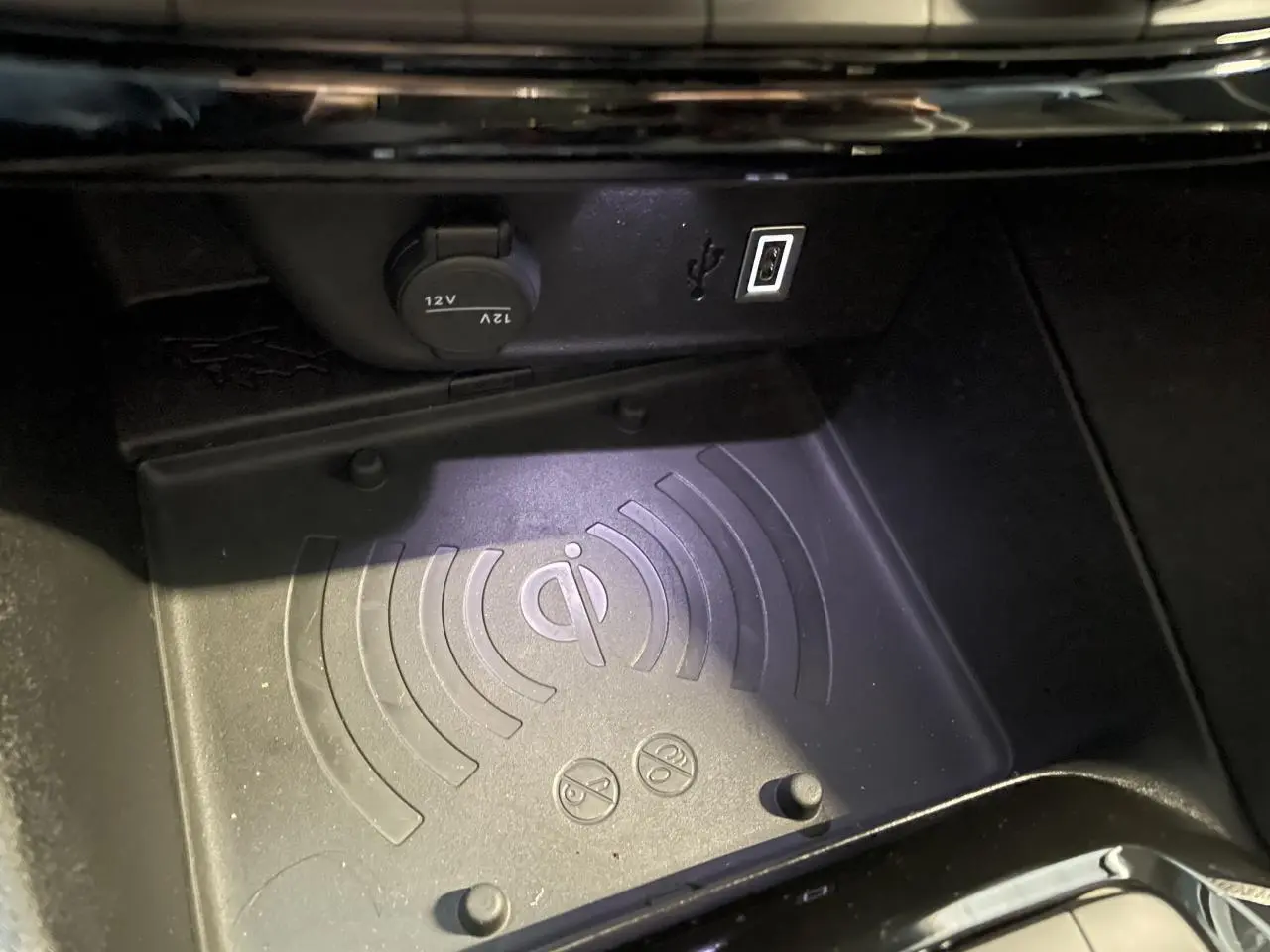 Gros plan sur le chargeur à induction et prises USB dans la console centrale de l’Opel Corsa blanche.
