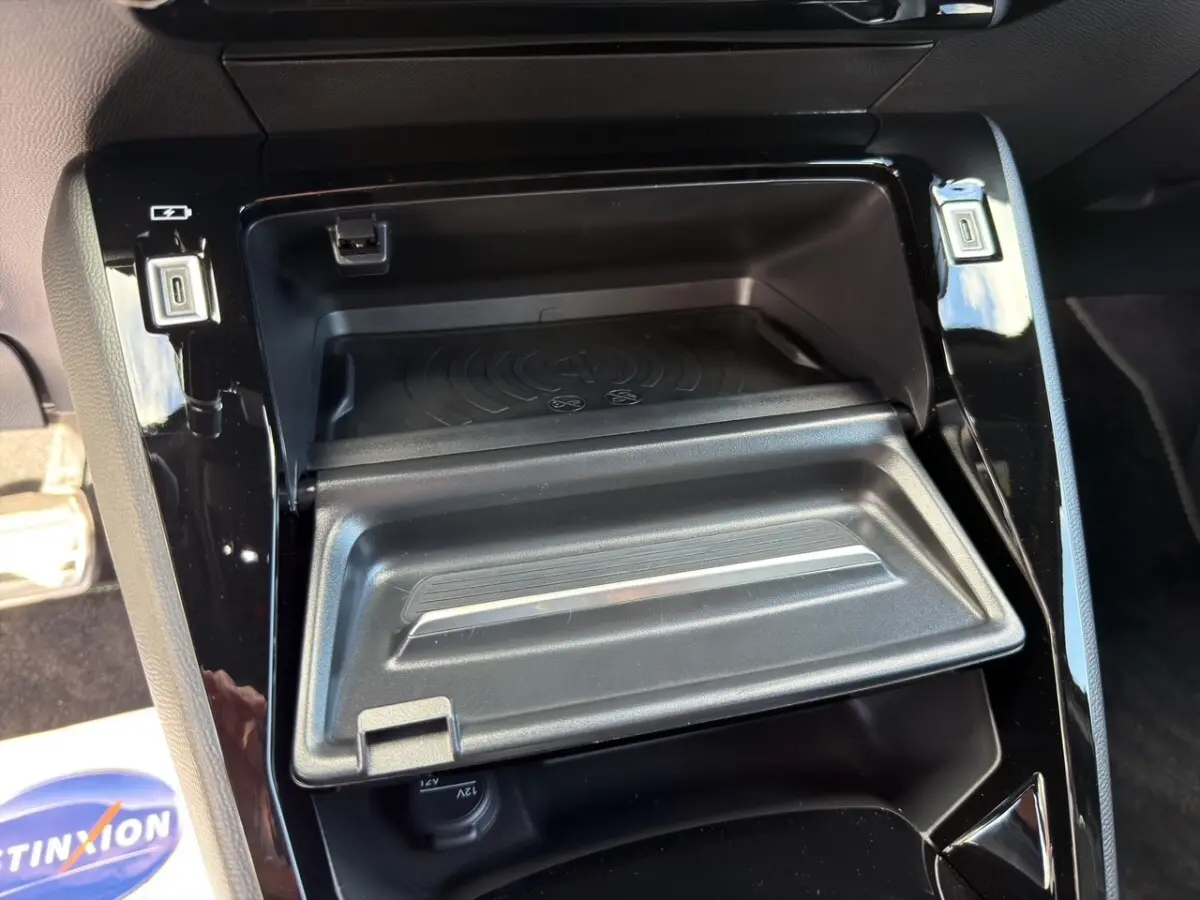Vue rapprochée de la console centrale noire du Peugeot 2008 Hybrid 145 e-DCS6 GT avec rangement et ports USB visibles.