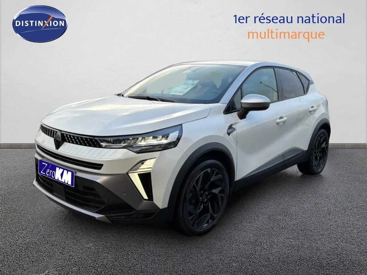 Renault Captur 2025 blanc nacré vue 3/4 avant droit avec toit gris et jantes noires distinctives.