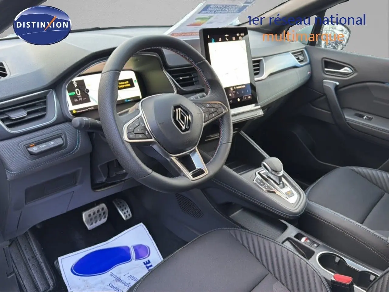 Vue intérieure côté conducteur du Renault Captur 2025 blanc nacré, volant multifonction et écran tactile vertical.