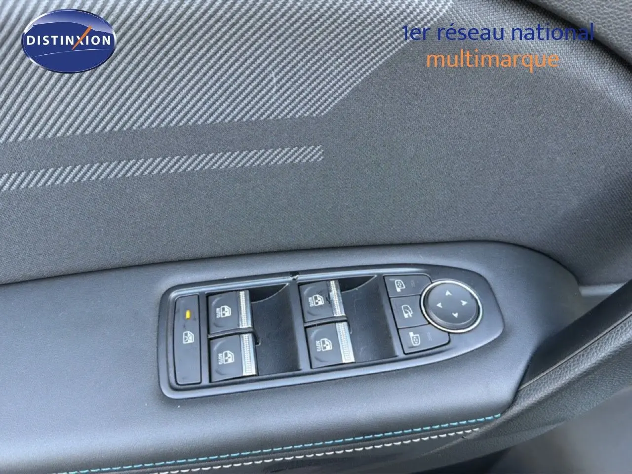 Gros plan sur les commandes des vitres et rétroviseurs côté gauche d’un Renault Captur blanc nacré toit gris.