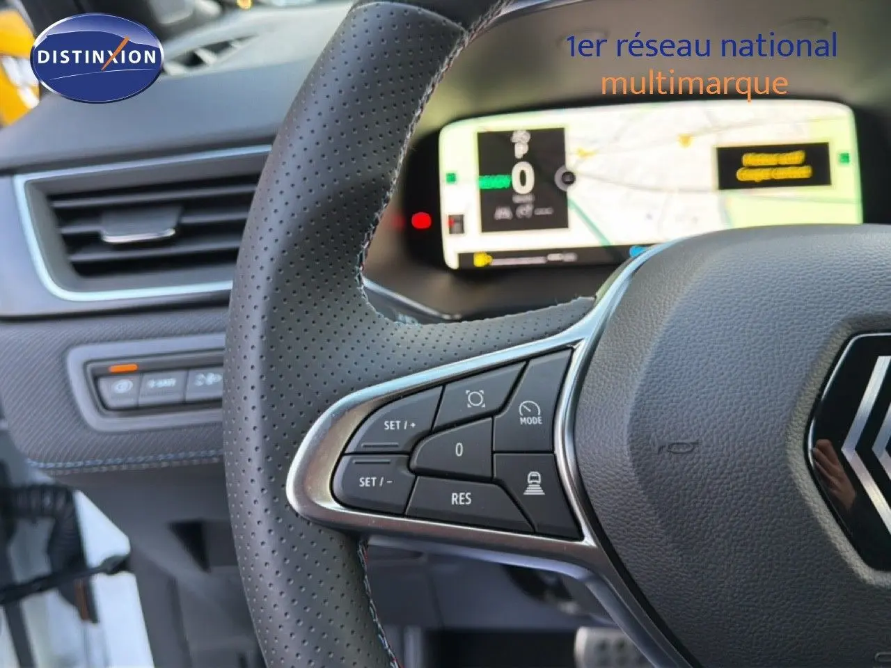 Gros plan sur le volant en cuir perforé et le tableau de bord numérique du Renault Captur blanc nacré 2025.