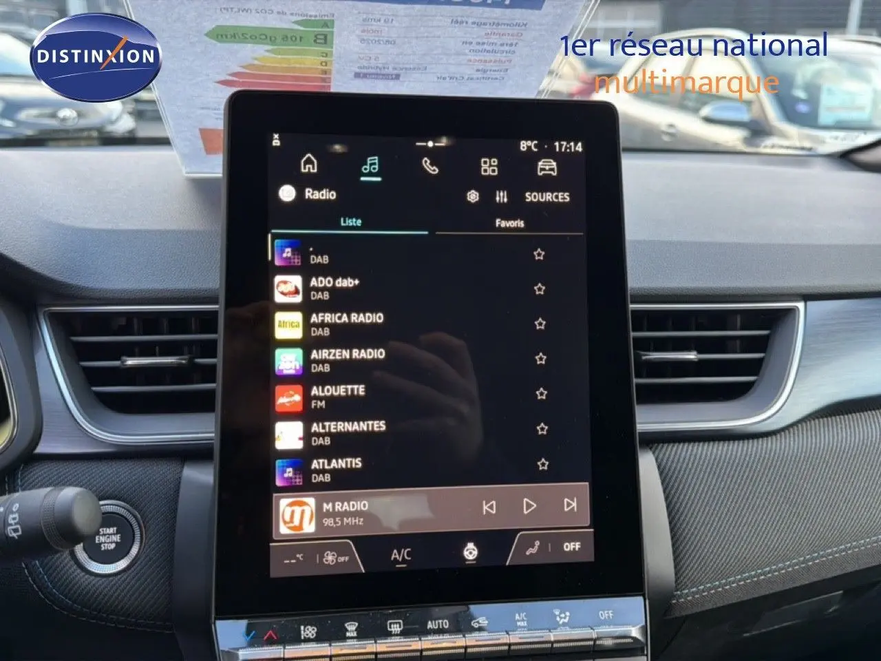 Vue intérieure centrée sur l'écran tactile multimédia du Renault Captur blanc nacré avec toit gris, tableau de bord moderne.