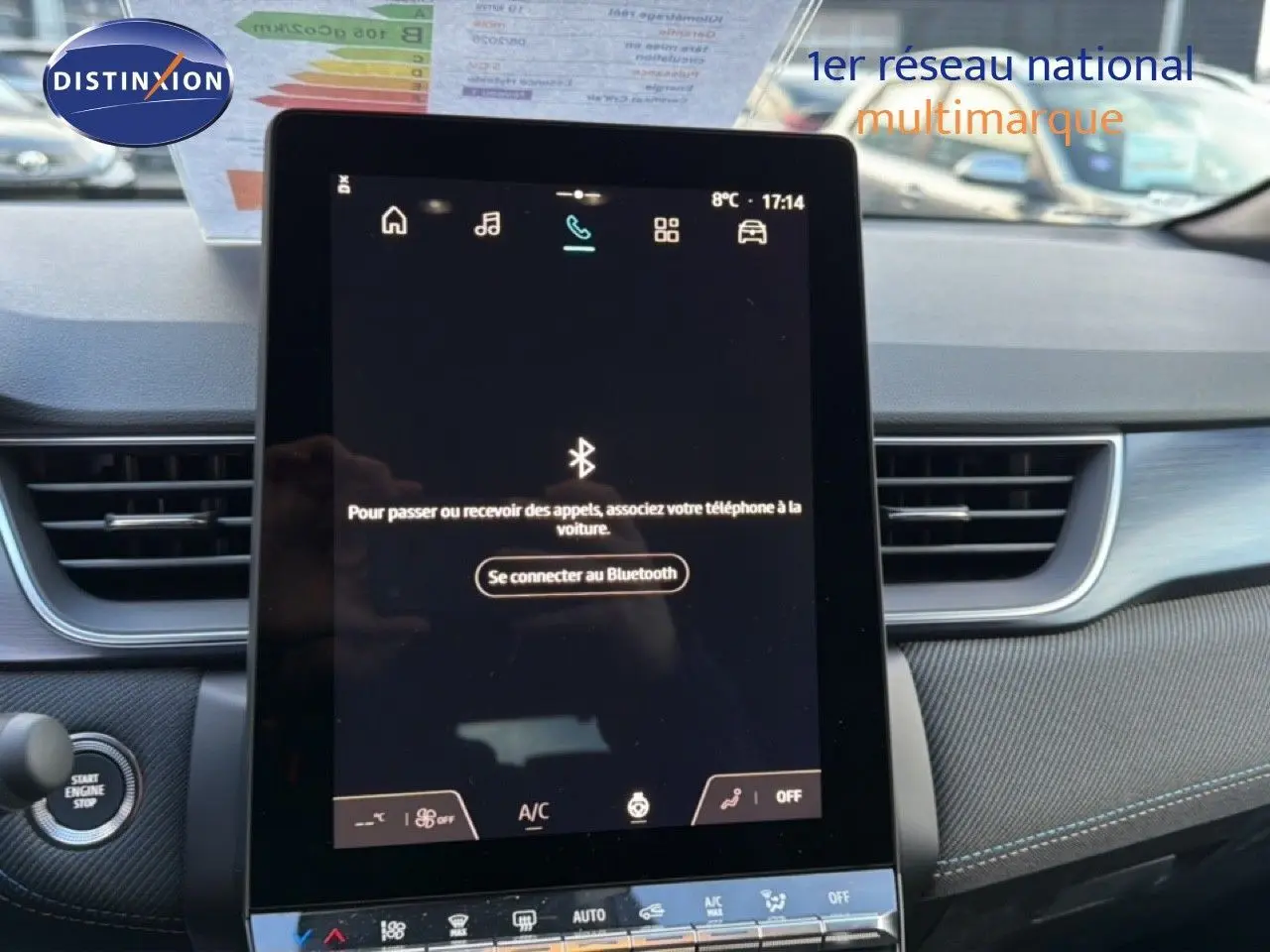 Intérieur de Renault Captur 2025, vue frontale sur l’écran tactile central avec commandes climatisation et démarrage moteur.