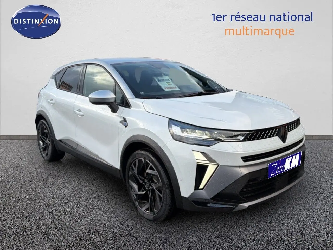 Renault Captur 2025 blanc nacré avec toit gris, vue 3/4 avant droit, jantes noires et feux LED distinctifs.