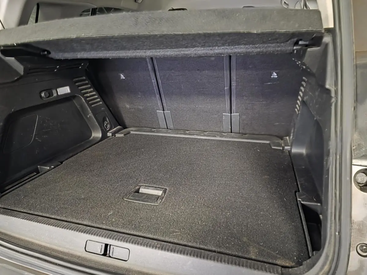 Coffre ouvert vu de l'arrière d'un Citroën C5 Aircross gris, montrant le plancher plat et les sièges arrière rabattus.