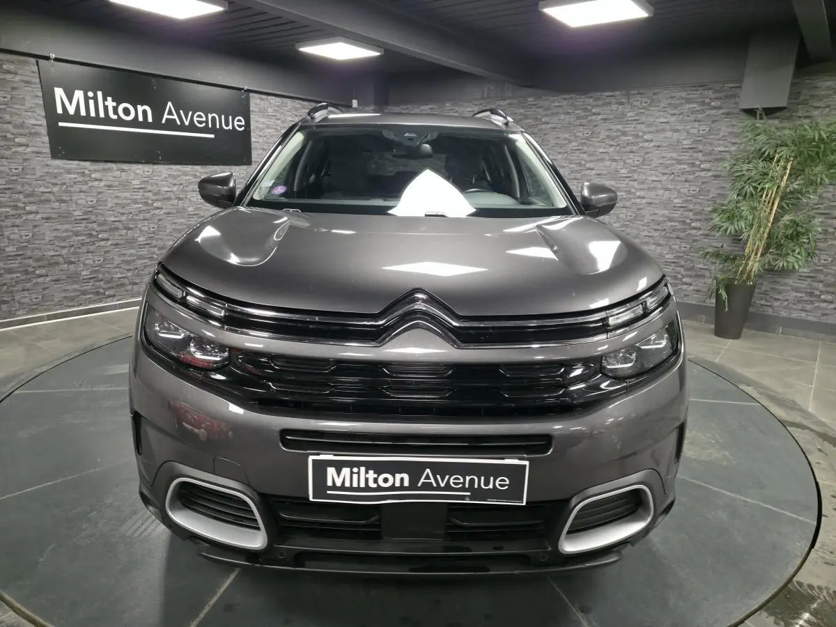Vue frontale d'un Citroën C5 Aircross gris métallisé avec calandre noire brillante et détails chromés.
