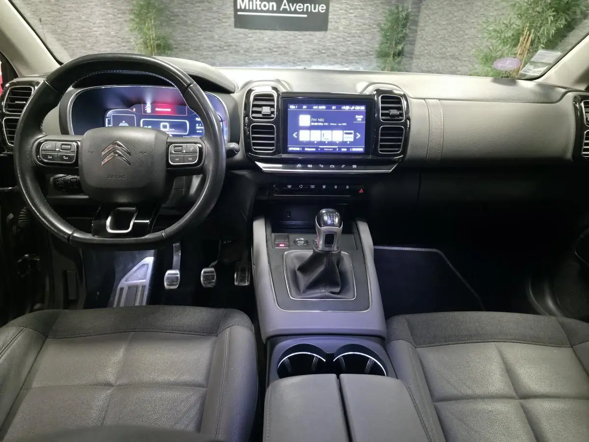 Intérieur du Citroën C5 Aircross 2019, vue du poste de conduite avec volant cuir et écran tactile central.