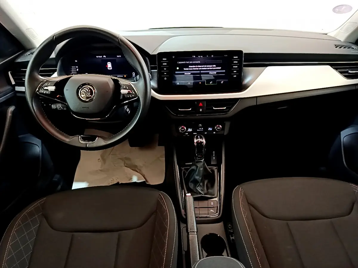 Intérieur de la Skoda Kamiq 2022 vue de face, tableau de bord moderne avec écran tactile et volant cuir noir.