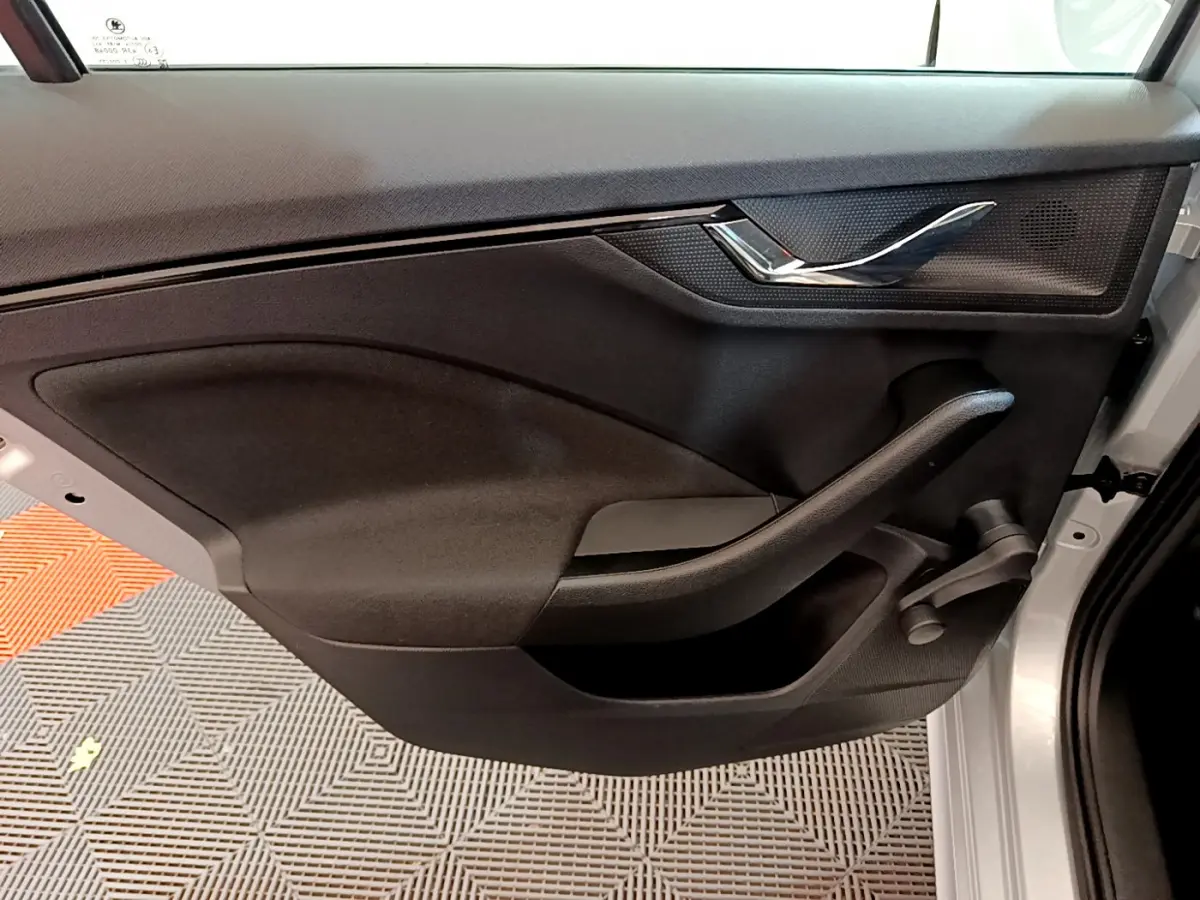 Vue intérieure de la porte arrière droite noire du Skoda Kamiq gris clair 2022 avec poignée manuelle de vitre.