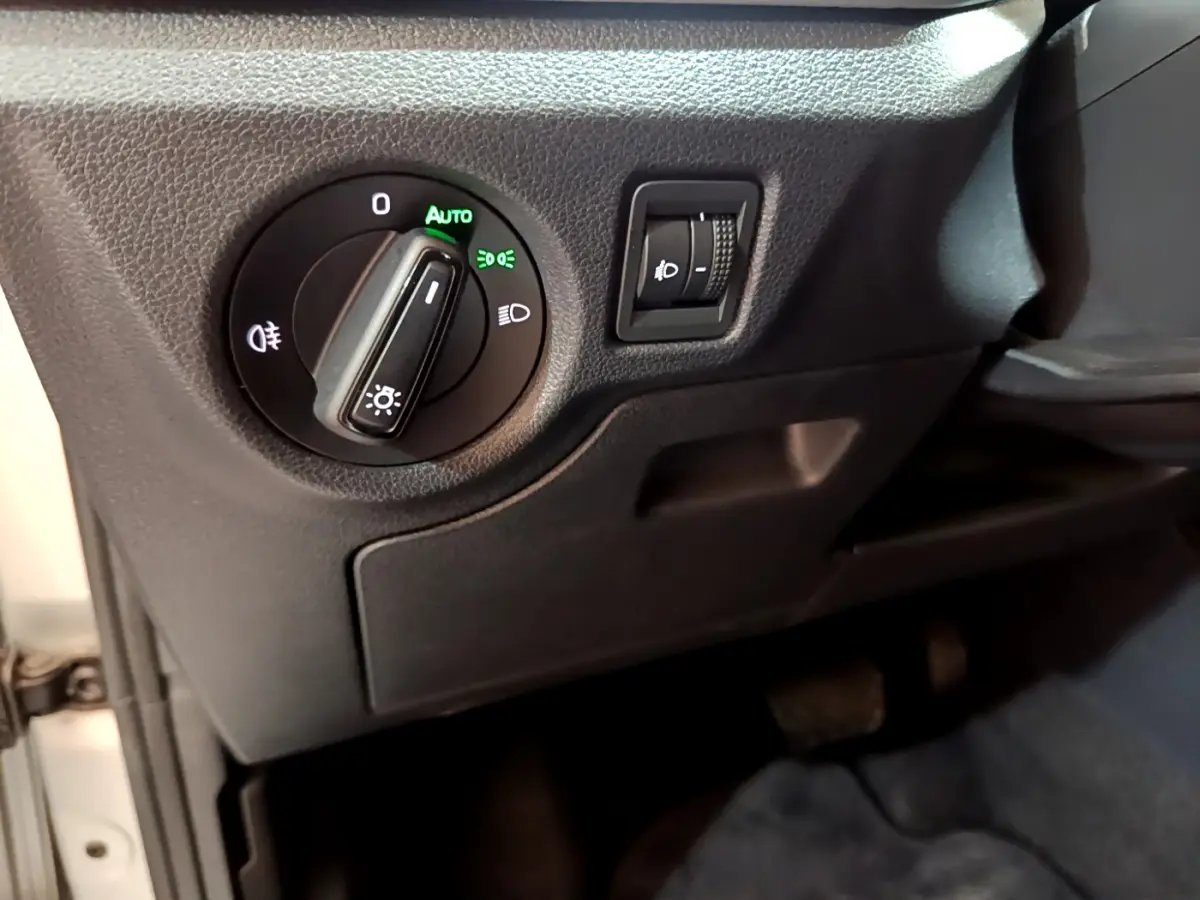 Gros plan sur les commandes d’éclairage noir mat côté gauche du tableau de bord du Skoda Kamiq gris clair 2022.