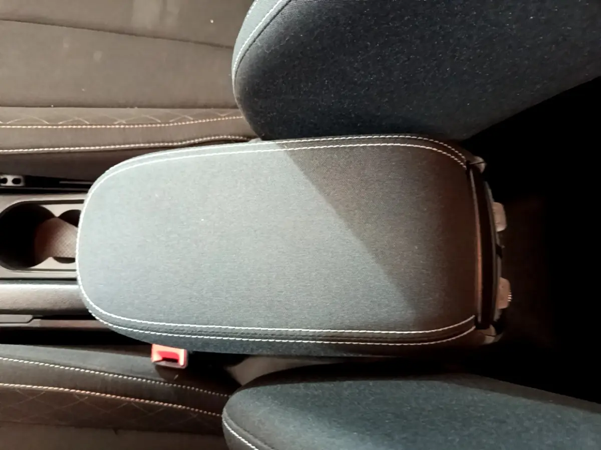 Accoudoir central noir avec surpiqûres blanches dans l'habitacle du Skoda Kamiq gris clair 2022.