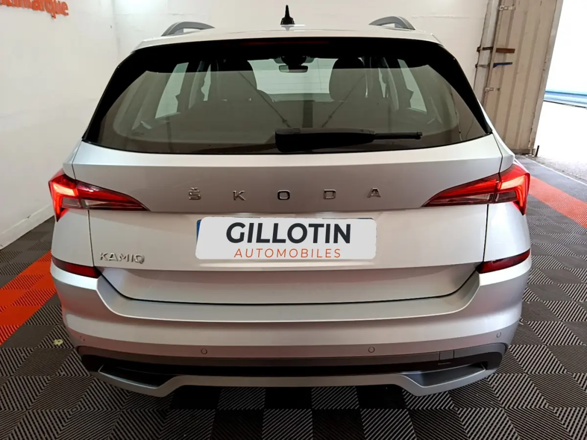 Vue arrière d'un ŠKODA KAMIQ gris clair 2022 avec feux LED et logo ŠKODA centré sur le hayon.