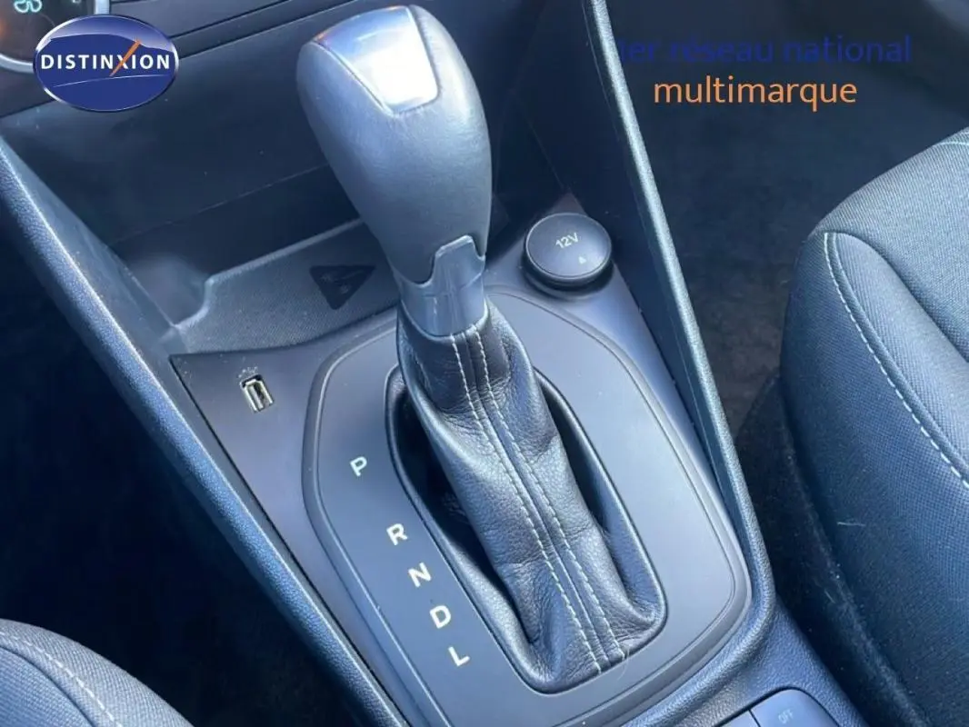 Gros plan sur le levier de vitesses automatique noir dans l'habitacle de la Ford Fiesta blanche, côté siège passager.