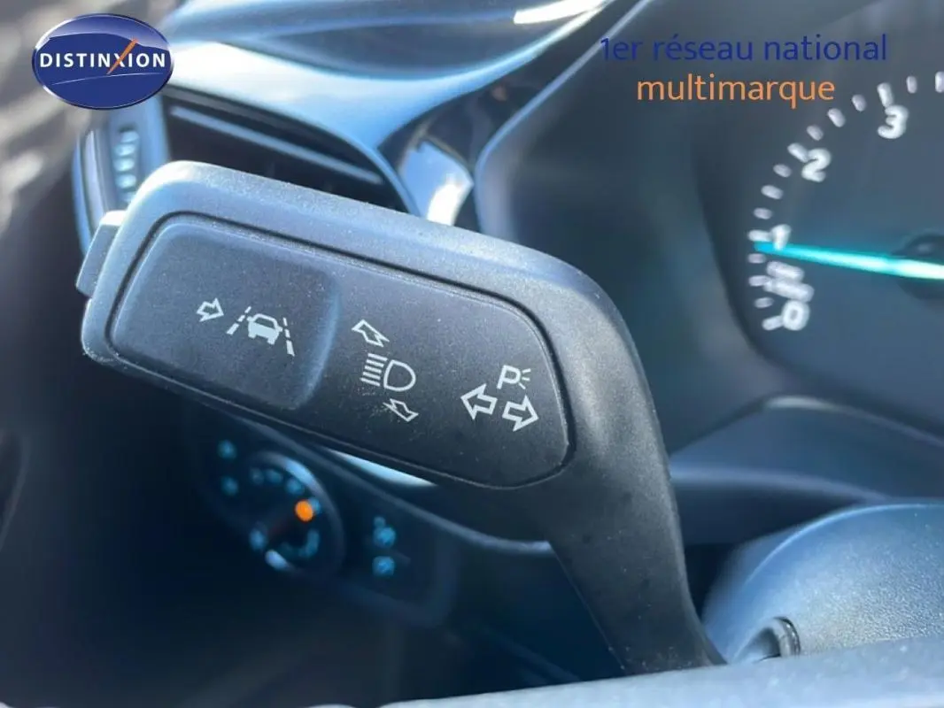 Gros plan sur le commodo de clignotants dans l’habitacle d’une Ford Fiesta blanche de 2020, avec tableau de bord en arrière-plan.