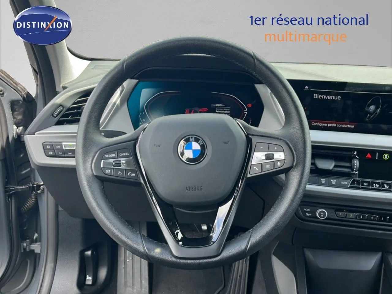 Vue intérieure centrée sur le volant cuir noir et tableau de bord numérique de la BMW Série 1 116i 2022 gris Frozen Pure.