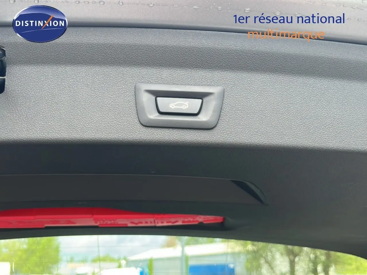 Bouton d'ouverture du coffre sur le hayon d'une BMW Série 1 116i 2022, couleur Frozen Pure Grey.