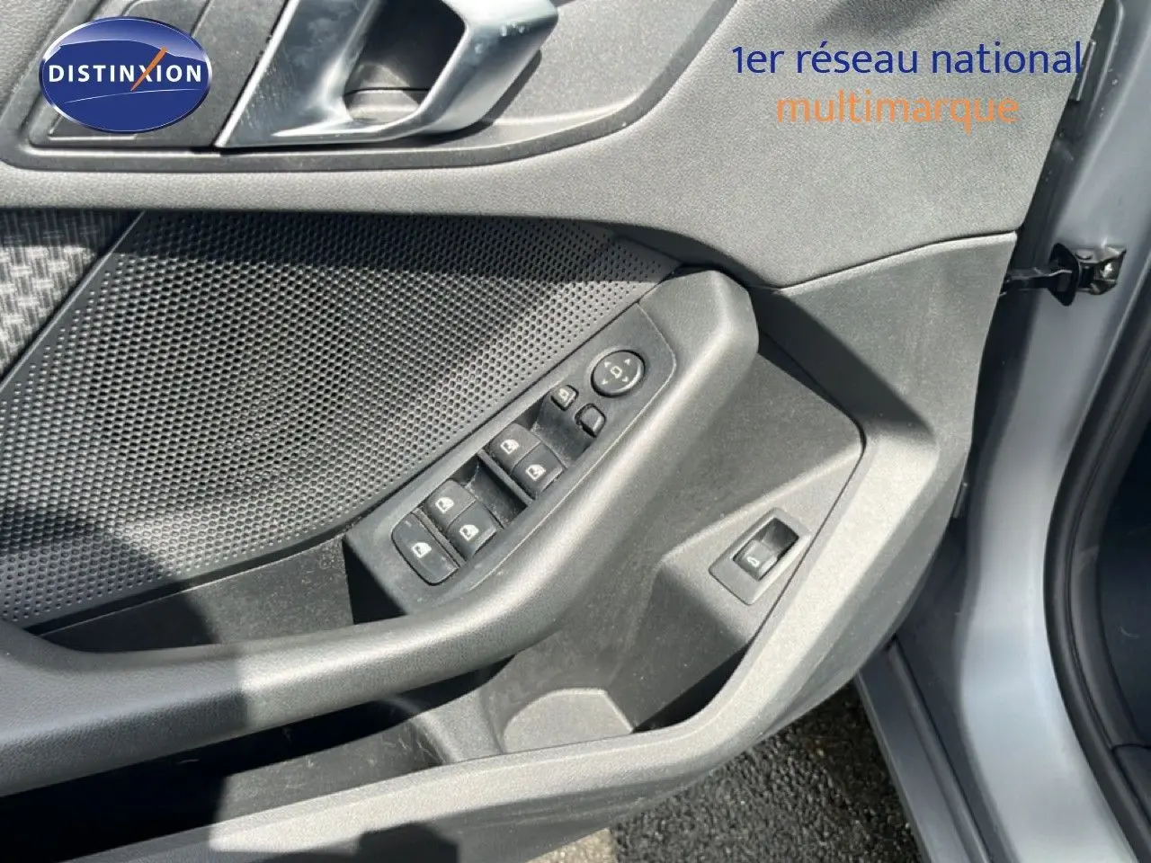 Détail du tableau de bord de la BMW Série 1 116i 2022, bouton des phares en mode automatique, finition gris texturé.