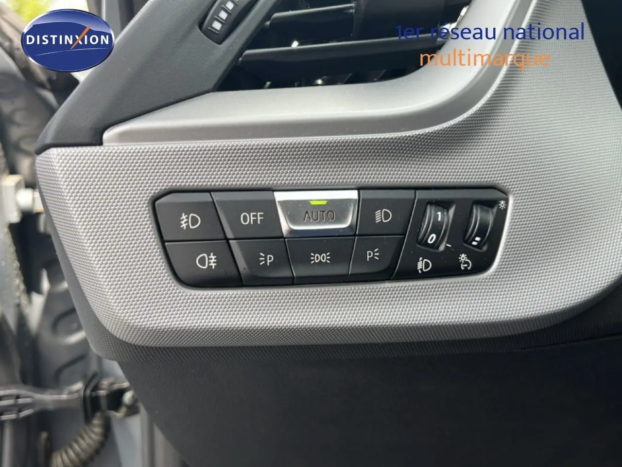 Détail des commandes de lève-vitres et réglage des rétroviseurs sur la porte côté gauche d’une BMW Série 1 gris mat.