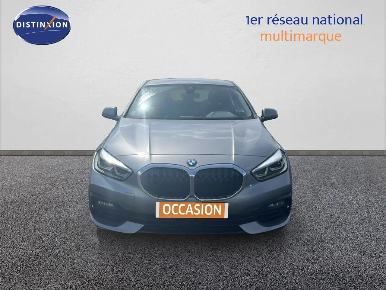 BMW Série 1 116i gris Frozen Pure Grey vue de face, mettant en valeur sa calandre et ses phares LED distinctifs.