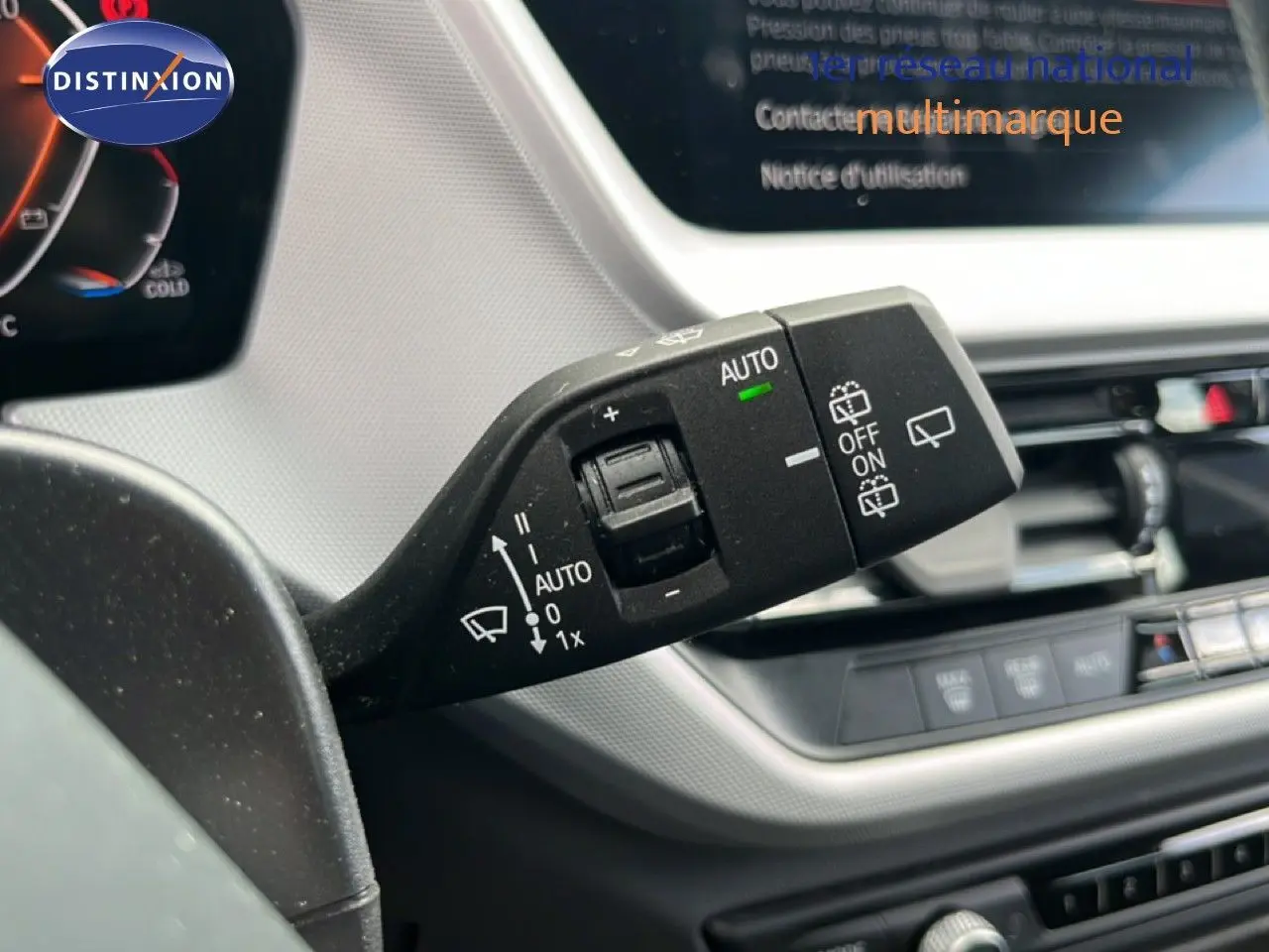 Gros plan sur la console centrale de la BMW Série 1 116i 2022, avec levier de vitesse et commandes multifonctions.