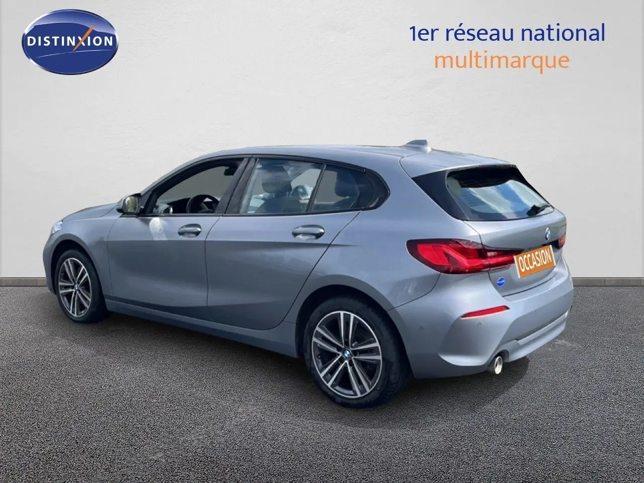 BMW Série 1 116i 2022 en Frozen Pure Grey vue 3/4 arrière droit, avec jantes alliage et feux LED distinctifs.