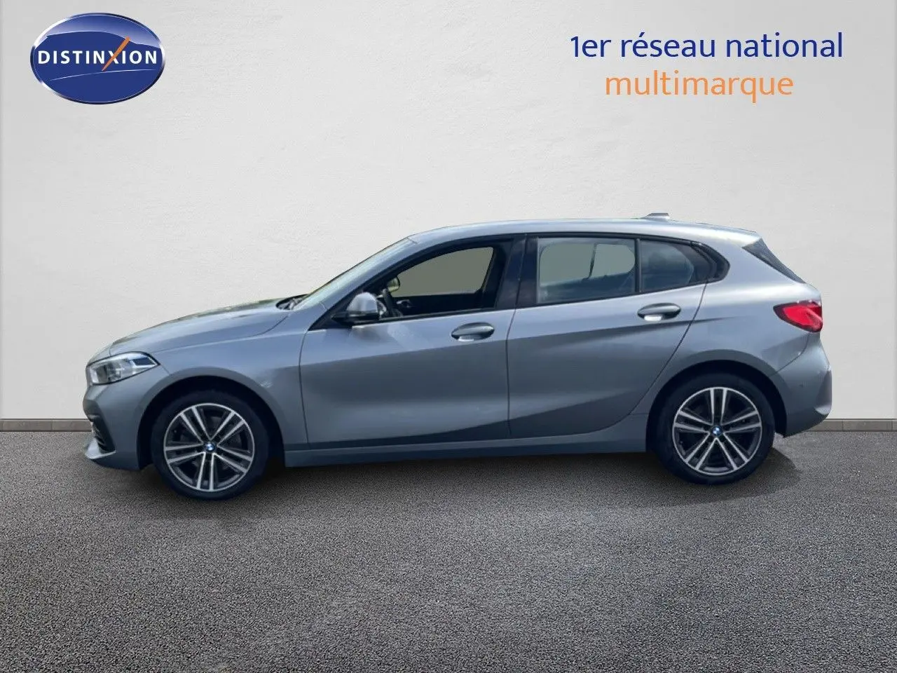 Profil droit d'une BMW Série 1 116i 2022 en gris mat Frozen Pure Grey avec jantes alliage bi-ton et vitres teintées.