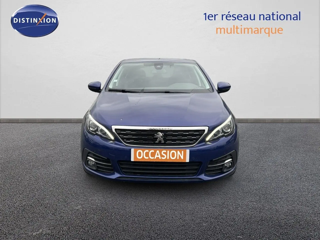 Vue frontale d'une Peugeot 308 Bleu Magnetic de 2020 avec phares LED et plaque "OCCASION" visible.