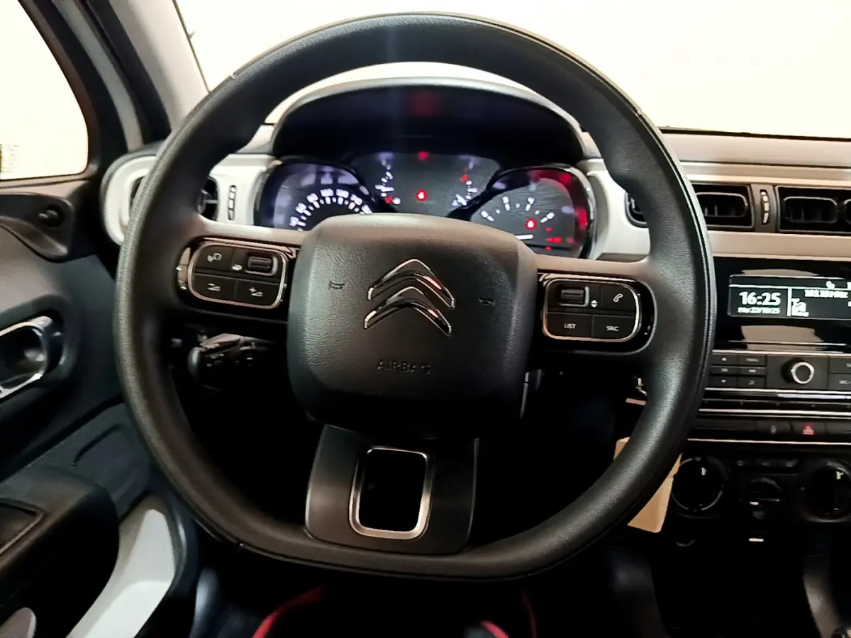 Vue rapprochée du volant noir de la Citroën C3 PureTech 68 BVM Live avec tableau de bord et console centrale visibles.