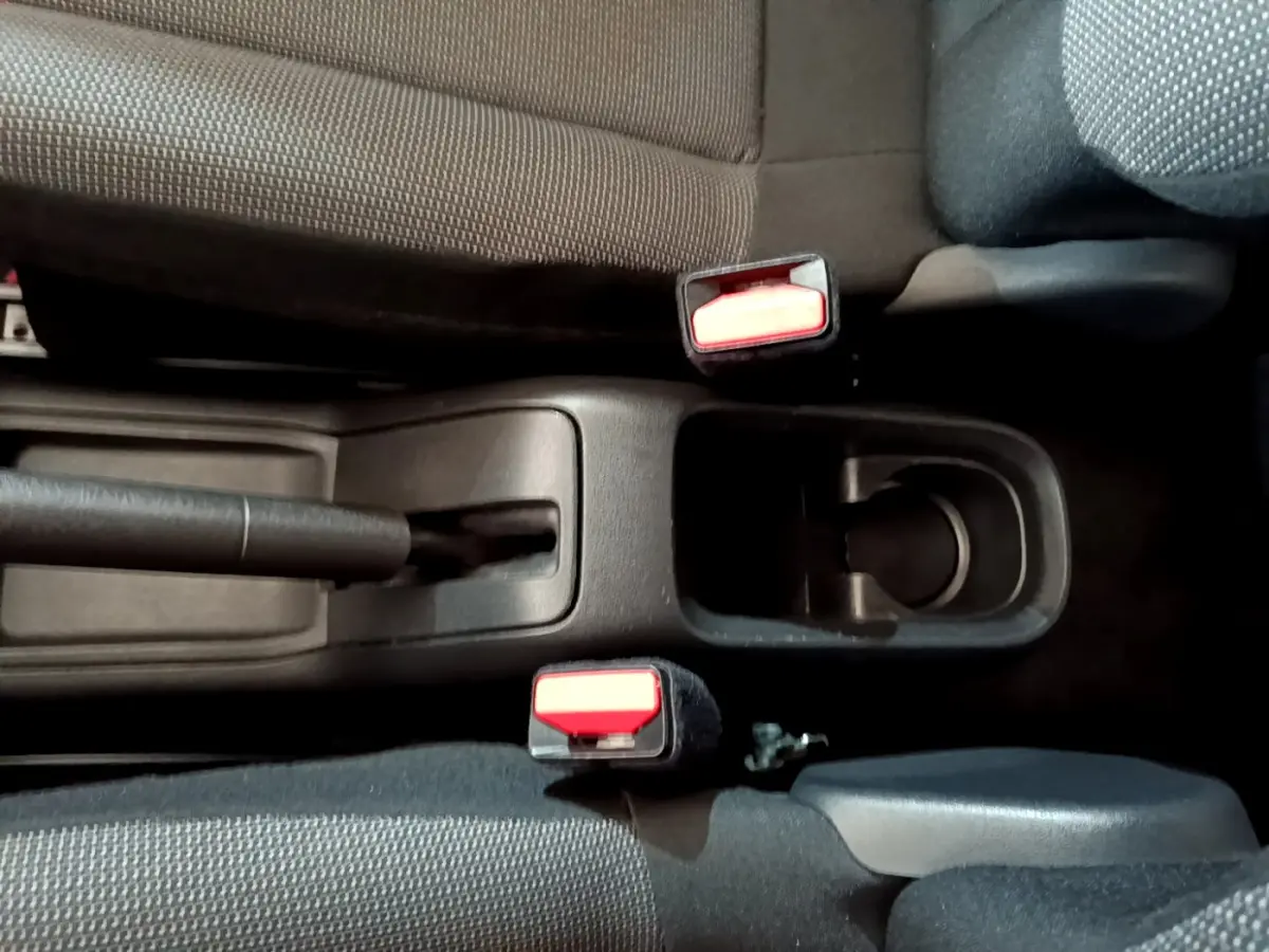 Vue rapprochée de la console centrale intérieure de la Citroën C3 blanche, montrant frein à main et ceintures de sécurité.