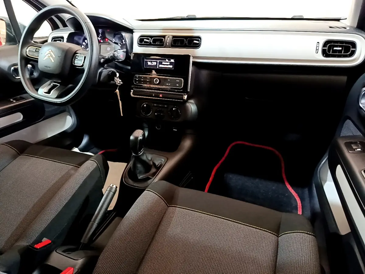 Vue intérieure avant droite du tableau de bord et des sièges noirs de la Citroën C3 PureTech 68 BVM Live 2018.