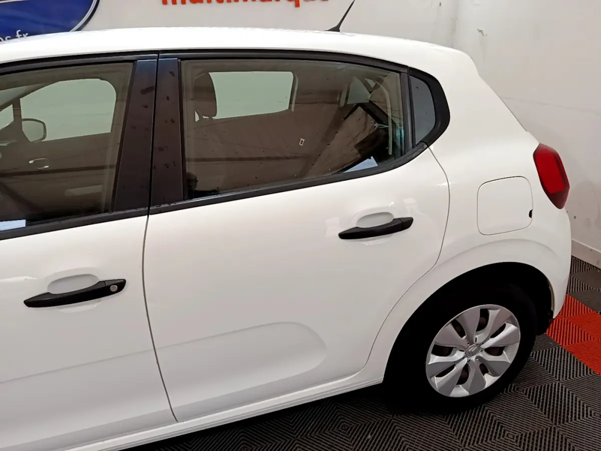 Vue latérale droite d'une Citroën C3 blanche de 2018, mettant en valeur les poignées noires et les jantes compactes.