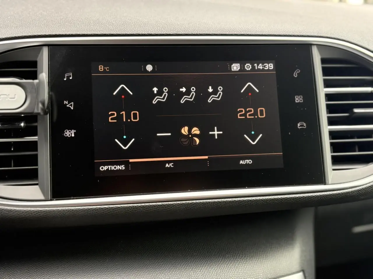 Écran tactile du tableau de bord de la Peugeot 308 blanc nacré affichant la climatisation bi-zone