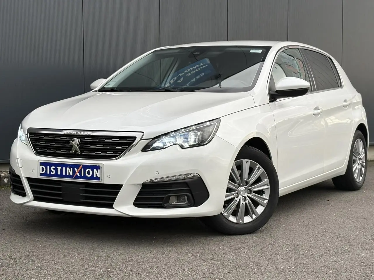 Peugeot 308 blanc nacré vue 3/4 avant droit avec projecteurs LED et jantes alliage 16 pouces.