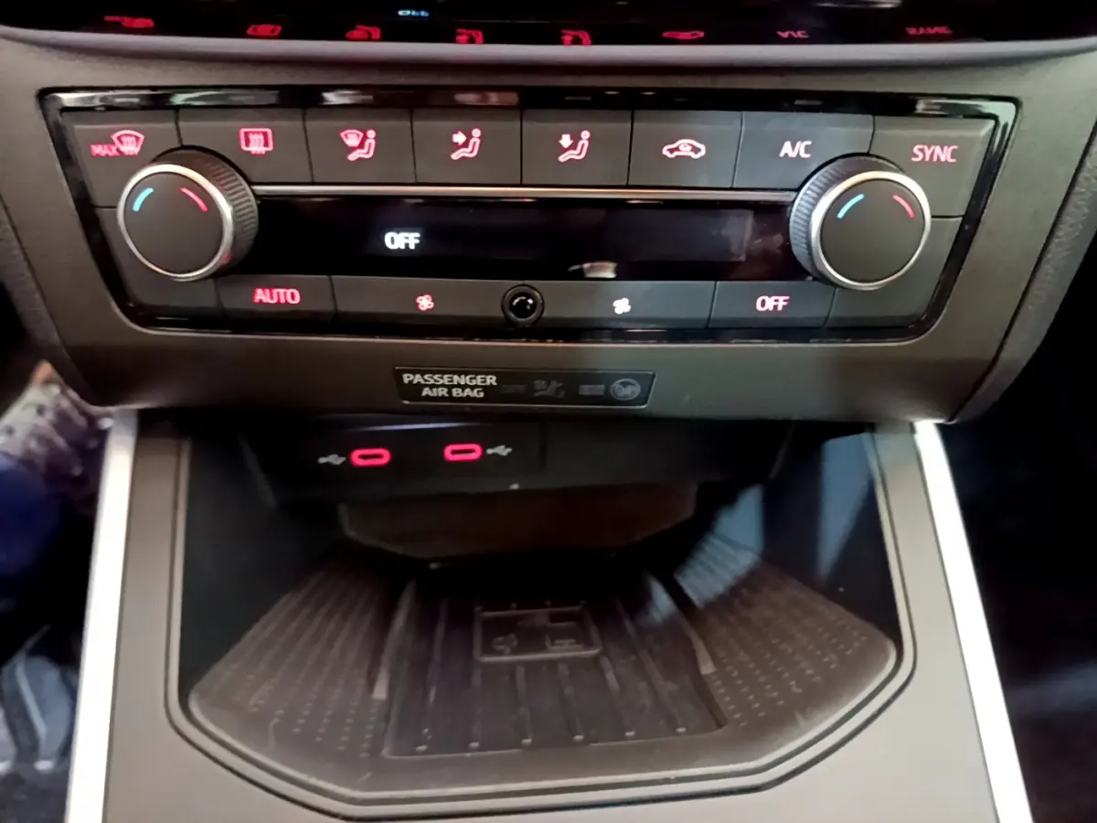 Vue rapprochée de la console centrale du SEAT Arona 2022, avec commandes climatisation et zone de recharge noire.