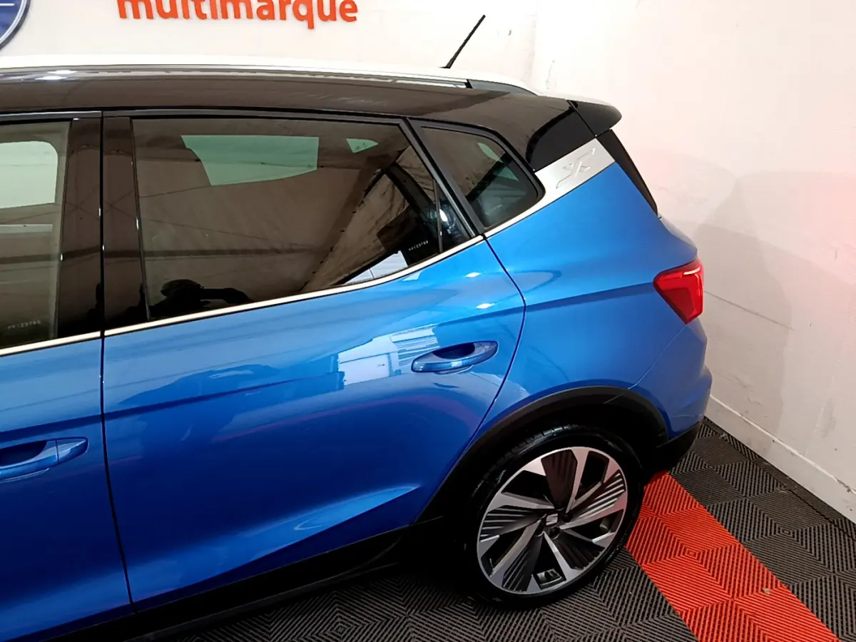 Vue côté arrière droit du SEAT Arona bleu 2022 avec jante alliage et toit noir contrasté.