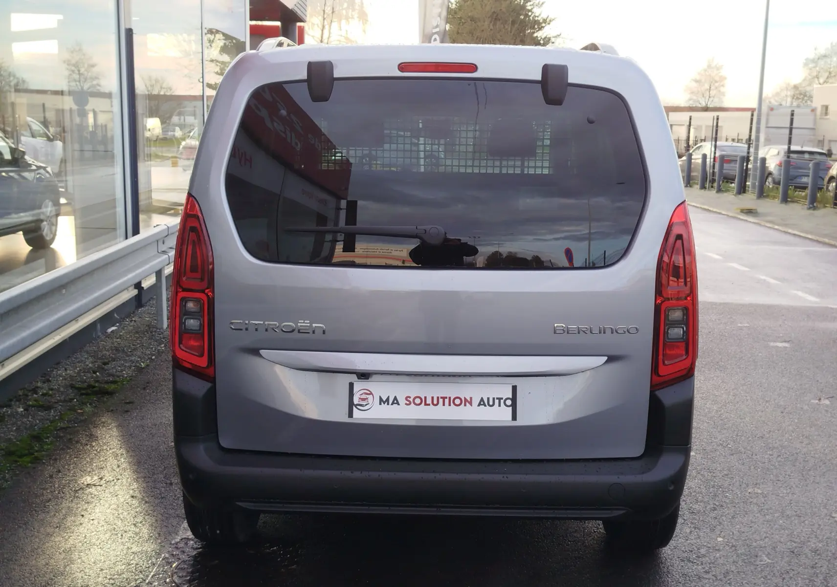 Vue arrière d’un Citroën Berlingo gris acier 2026 avec feux arrière verticaux et vitre arrière teintée.