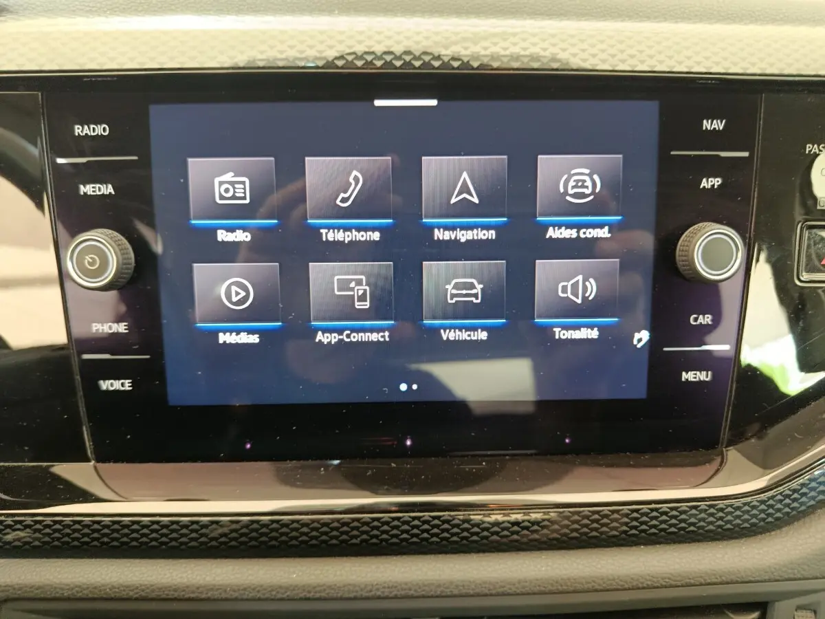 Écran tactile central du tableau de bord de la Volkswagen Polo gris clair, affichant le menu multimédia et navigation.