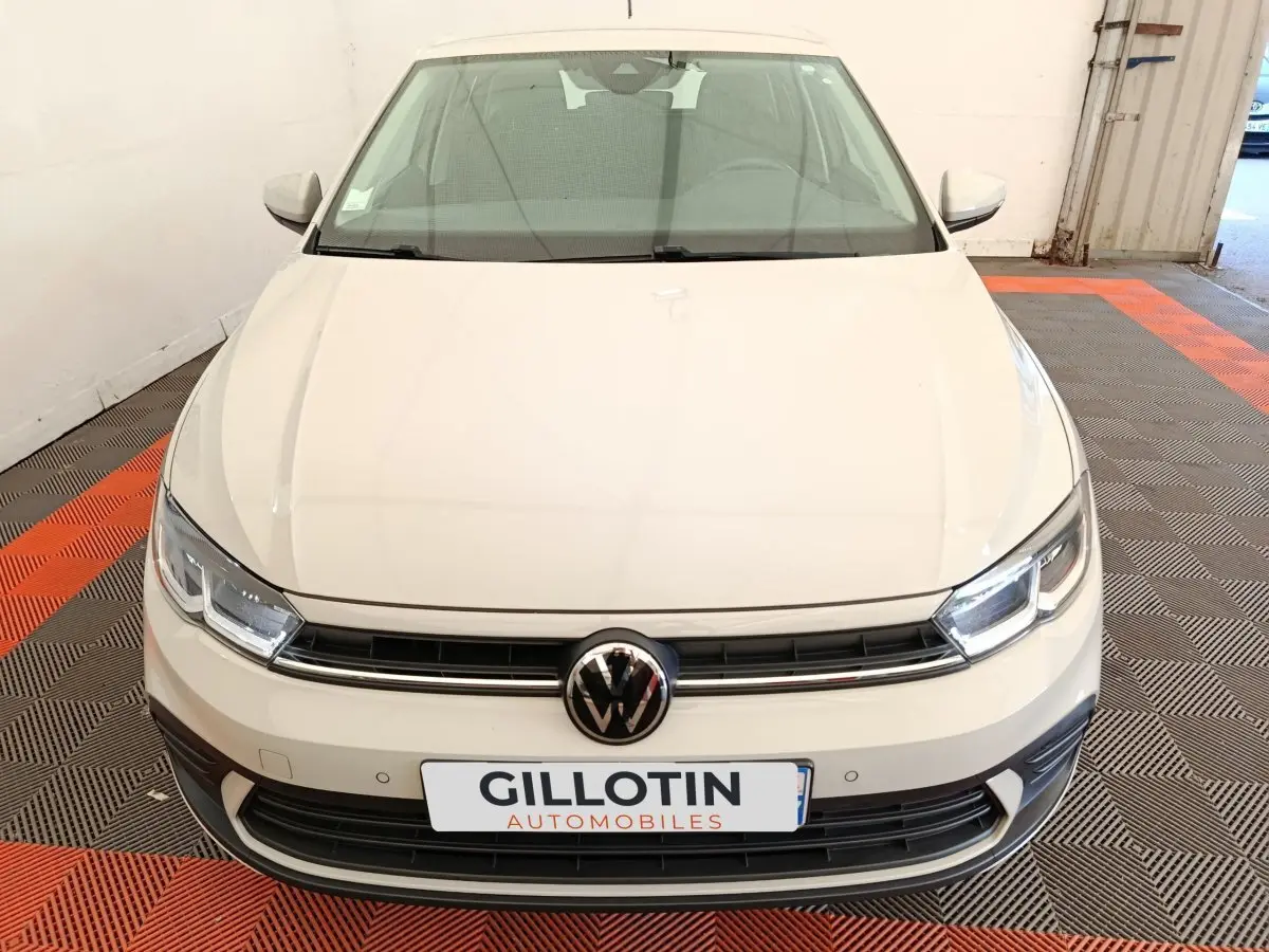 Vue avant d'une Volkswagen Polo gris clair 2023 avec calandre noire et logo VW centré.