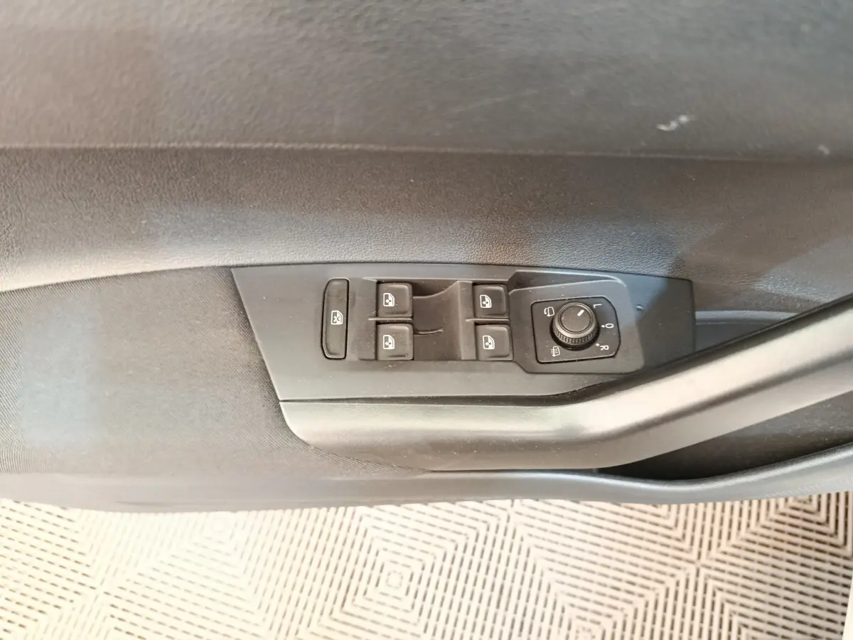 Commande des vitres et réglage des rétroviseurs côté gauche dans une Volkswagen Polo gris clair 2023.