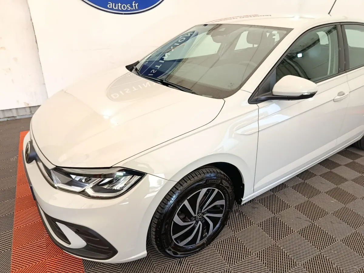 Vue 3/4 avant droit d'une Volkswagen Polo blanche avec jantes alliage et rétroviseurs blancs.