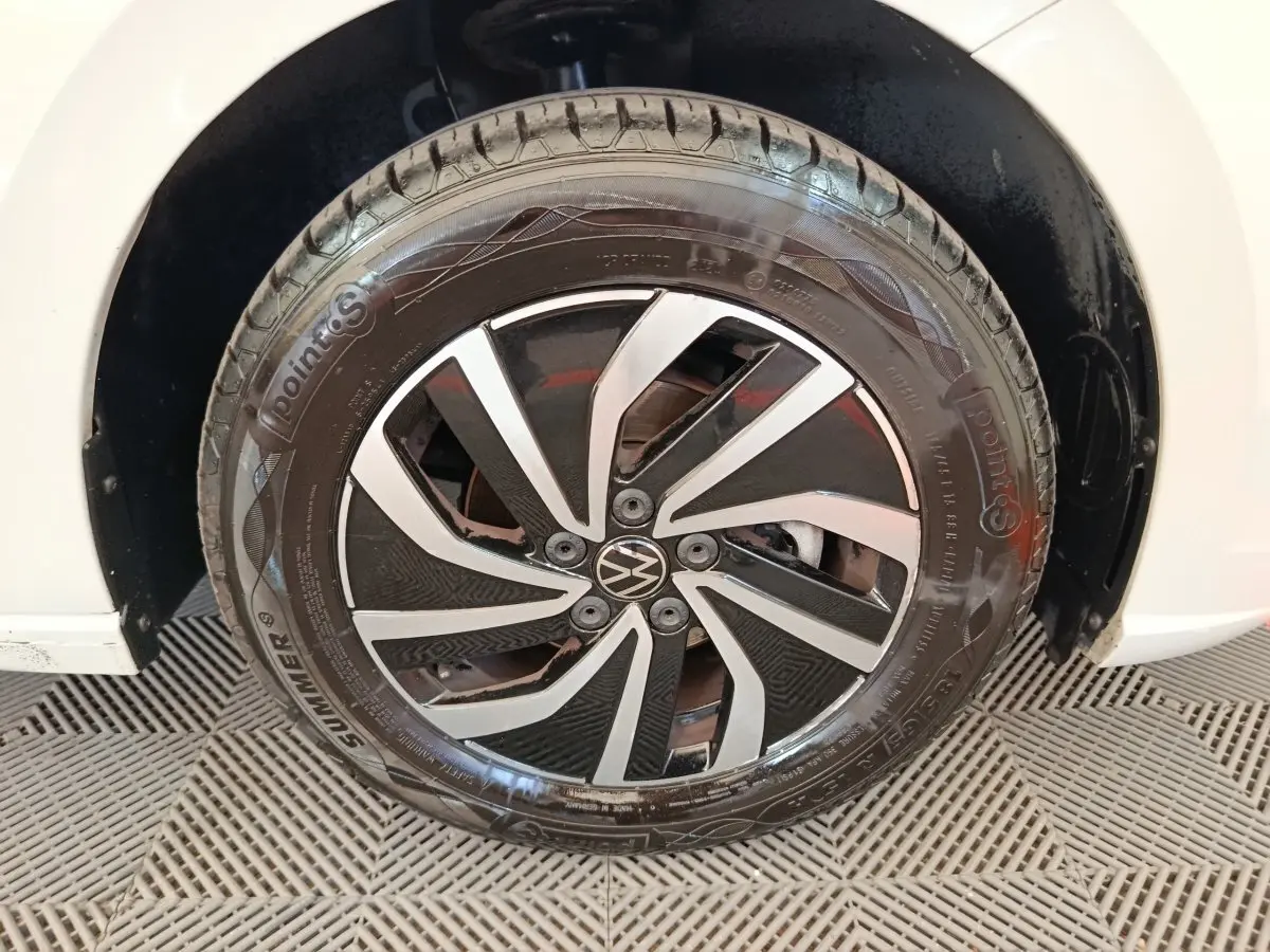 Gros plan sur la roue avant droite d'une Volkswagen Polo gris clair avec jante alliage noir et argent.