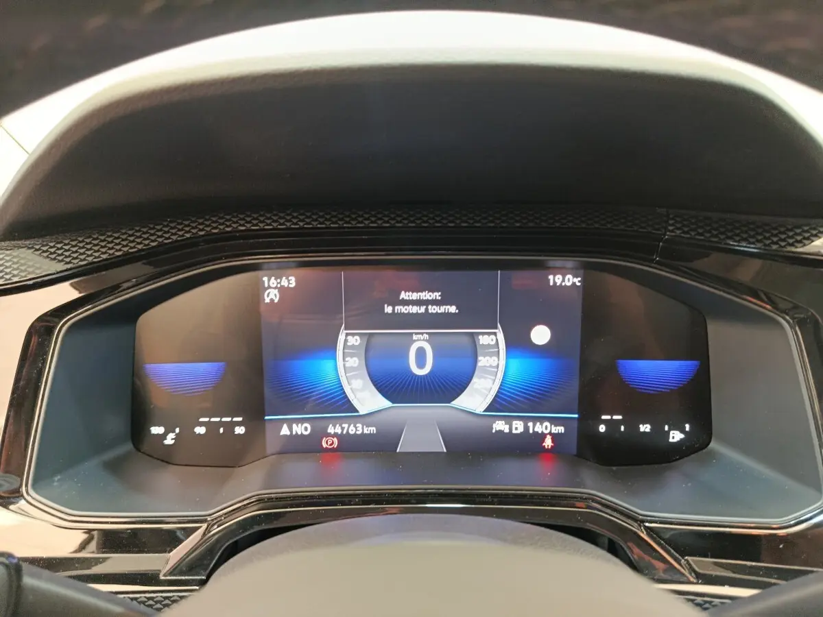 Vue rapprochée du tableau de bord numérique de la Volkswagen Polo 2023 affichant la vitesse à 0 km/h et diverses informations.