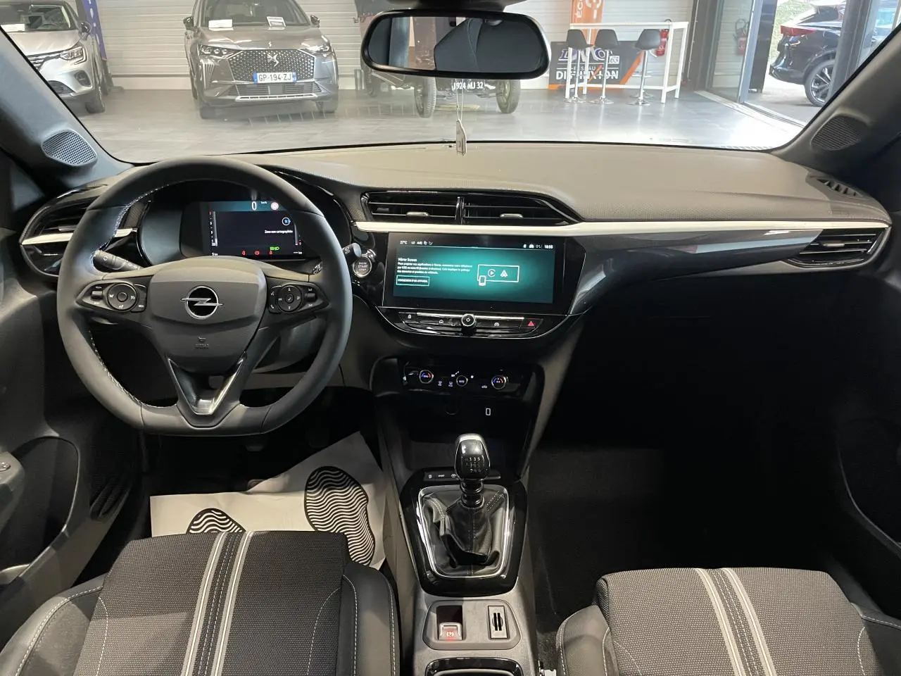 Vue intérieure avant de l'Opel Corsa gris, avec volant cuir, écran tactile 10 pouces et boîte manuelle.