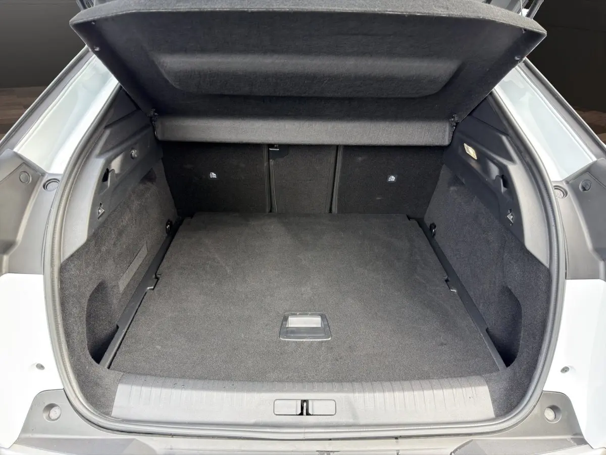 Coffre ouvert du Peugeot 3008 blanc, vue arrière montrant l'espace de chargement et la tablette cache-bagages.