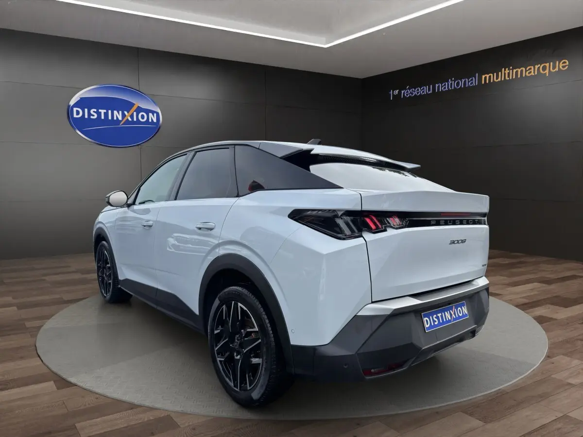 Vue 3/4 arrière droite du Peugeot 3008 blanc avec feux arrière LED et jantes noires en showroom.