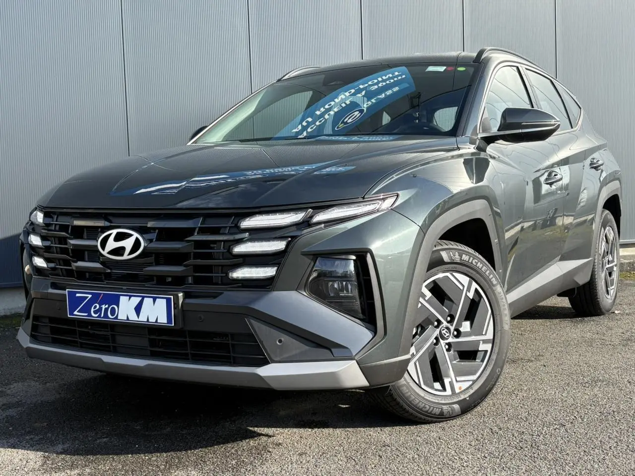 Vue 3/4 avant droite du Hyundai Tucson Cypress Green avec calandre noire et jantes alliage 17 pouces.