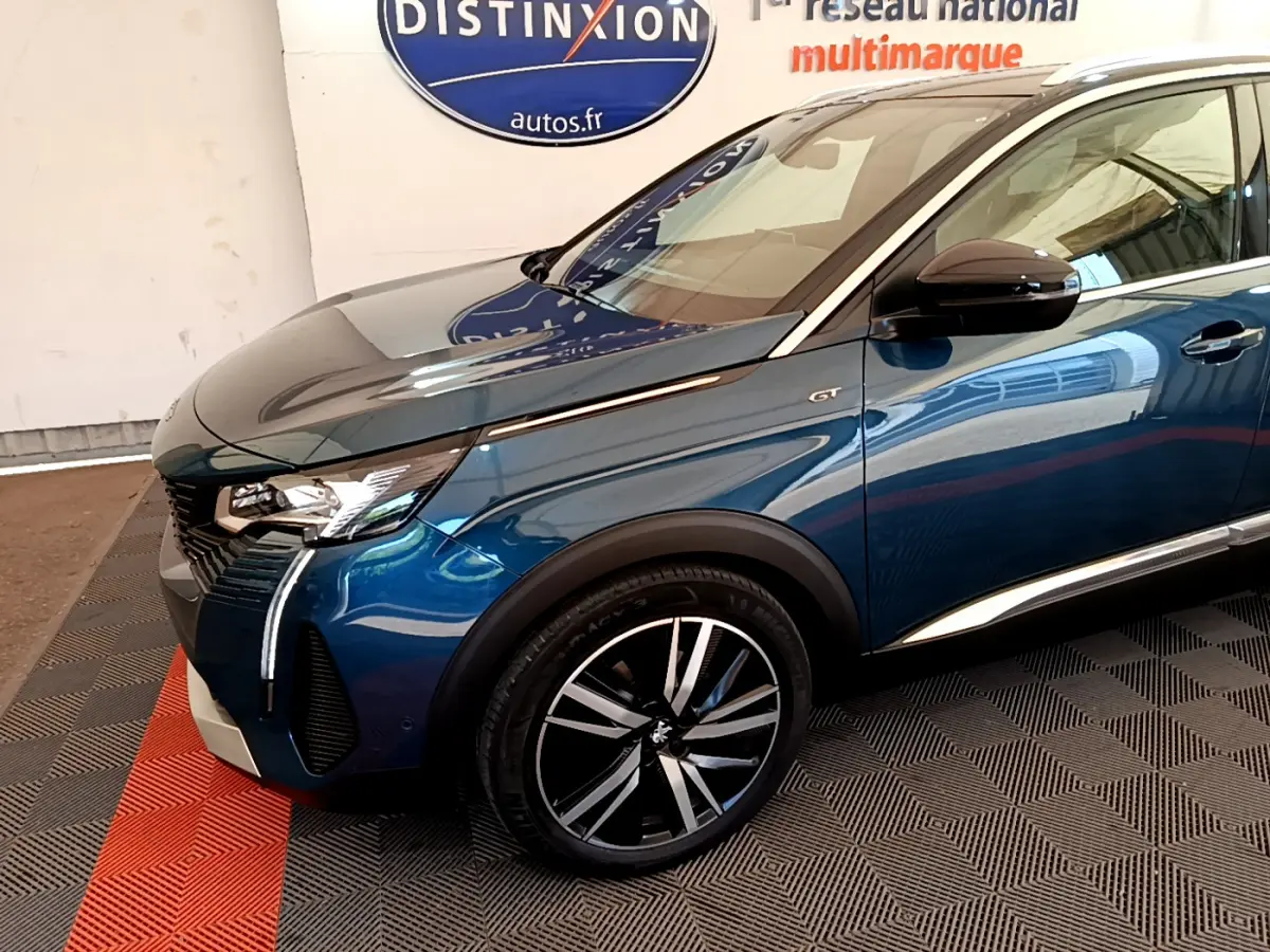 Vue 3/4 avant gauche d'un Peugeot 5008 GT Pack bleu avec jantes alliage et signature lumineuse LED verticale distinctive